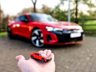 a hand holding a toy car